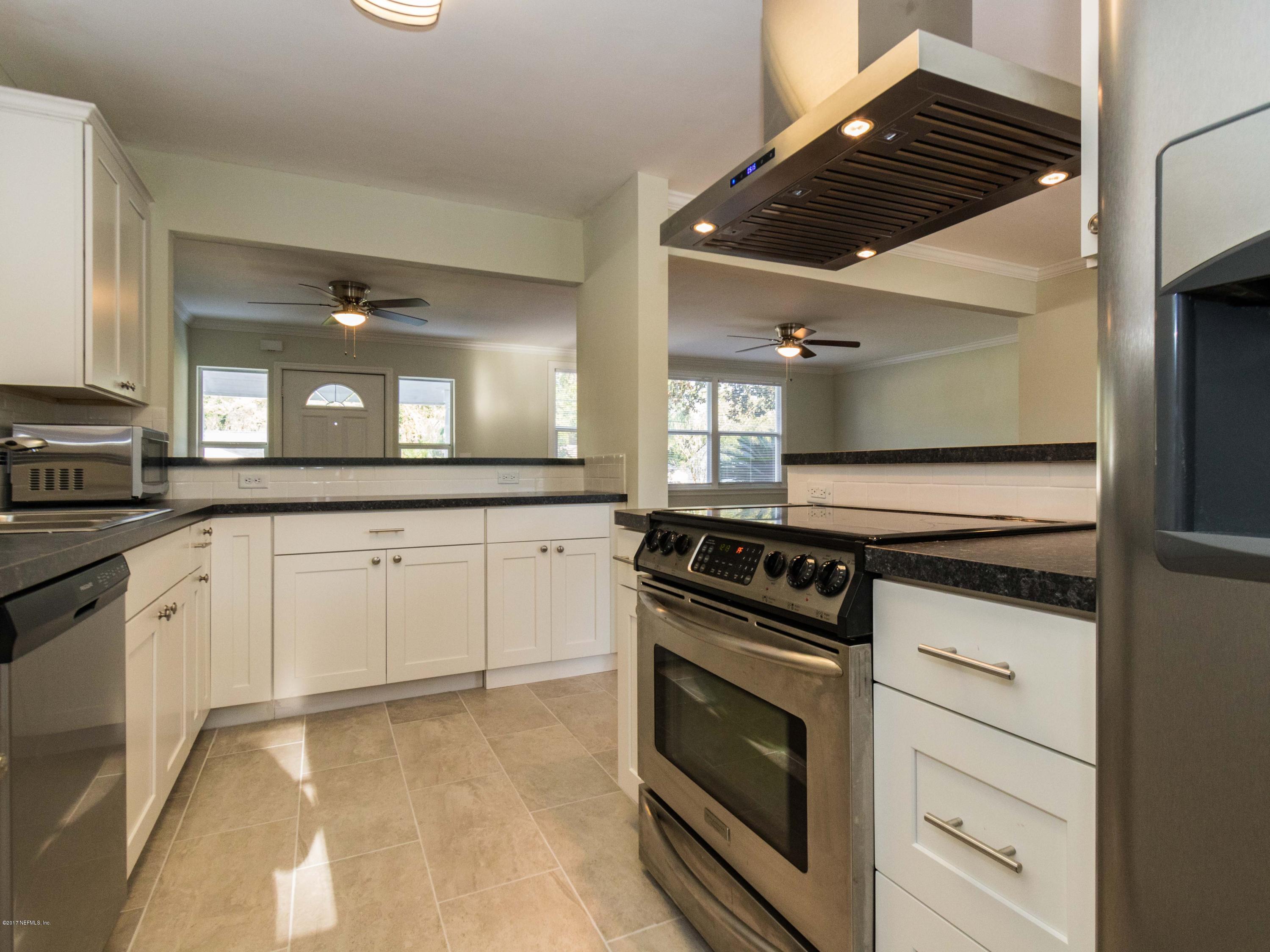 1764 Planters Road Jacksonville, FL 32207 - Photo 12 of 24 a kitchen with granite countertop a stove sink and cabinets