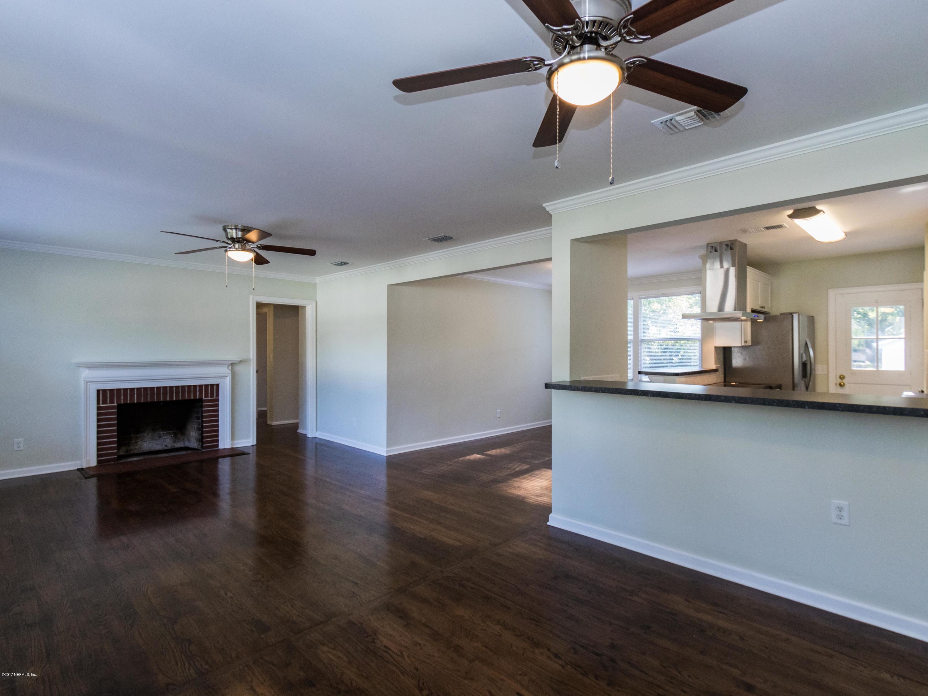 1764 Planters Road Jacksonville, FL 32207 - Photo 6 of 24 a view of a livingroom with a fireplace a ceiling fan and wooden floor