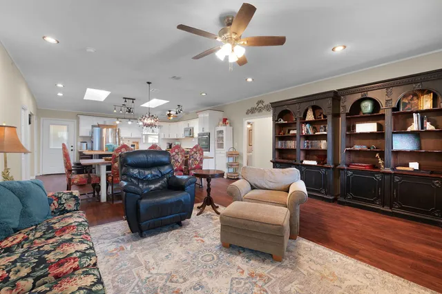 a living room with furniture cabinets and wooden floor