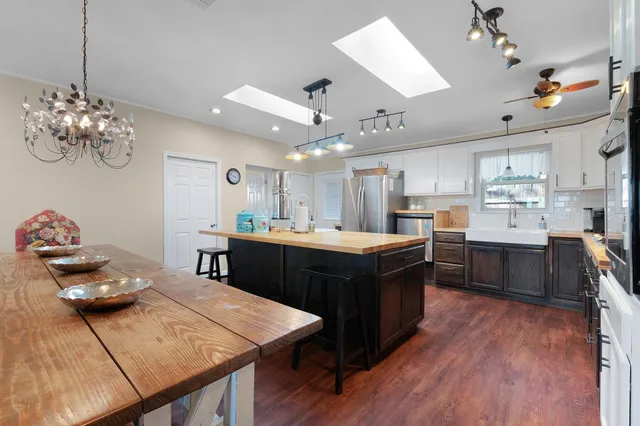a kitchen with granite countertop a sink cabinets and wooden floor