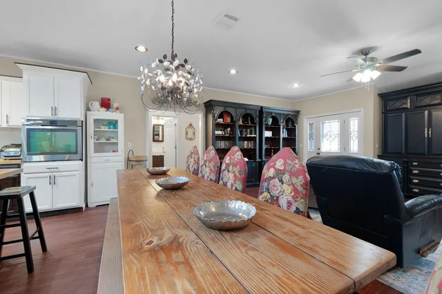 a living room with furniture chandelier and wooden floor