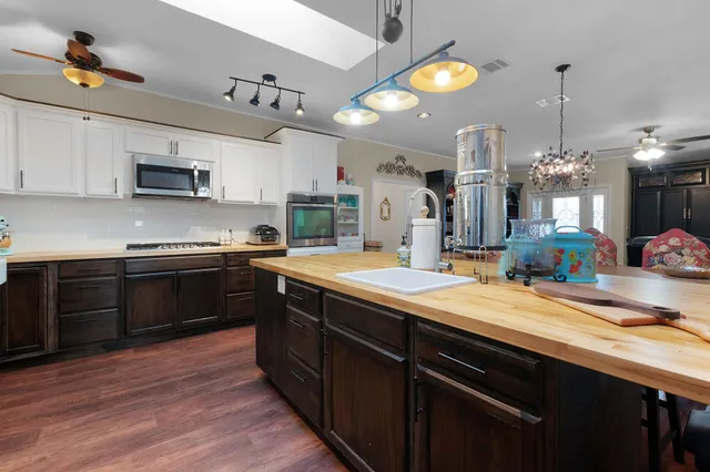 a kitchen with stainless steel appliances kitchen island granite countertop a stove a sink and a microwave