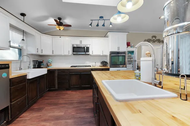 a kitchen with kitchen island granite countertop a sink a counter top space appliances and cabinets