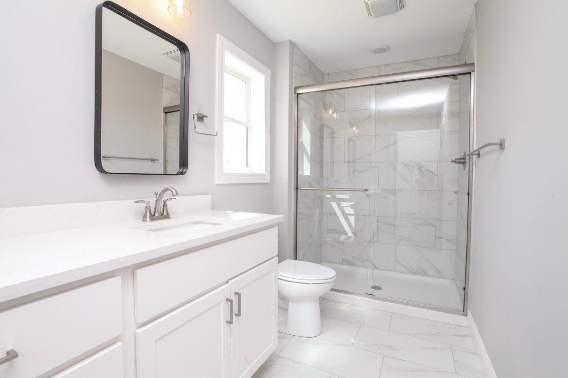 9 Brookstone Circle Bloomington, IL 61704 - Photo 26 of 40 a bathroom with a shower sink vanity mirror and toilet