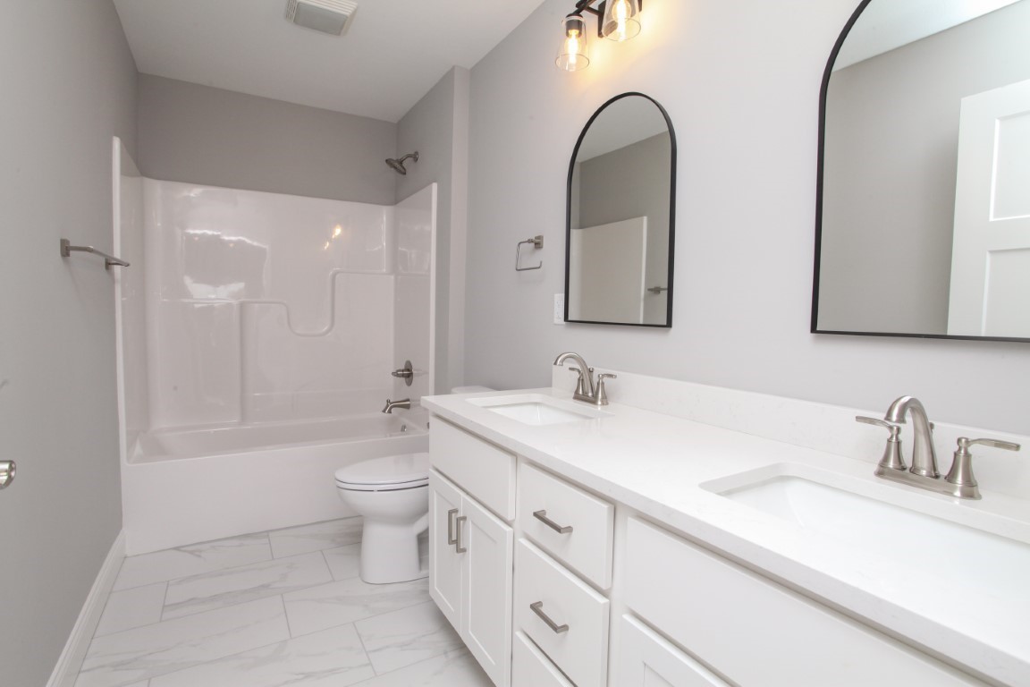 9 Brookstone Circle Bloomington, IL 61704 - Photo 33 of 40 a bathroom with a double vanity sink toilet mirror and bathtub