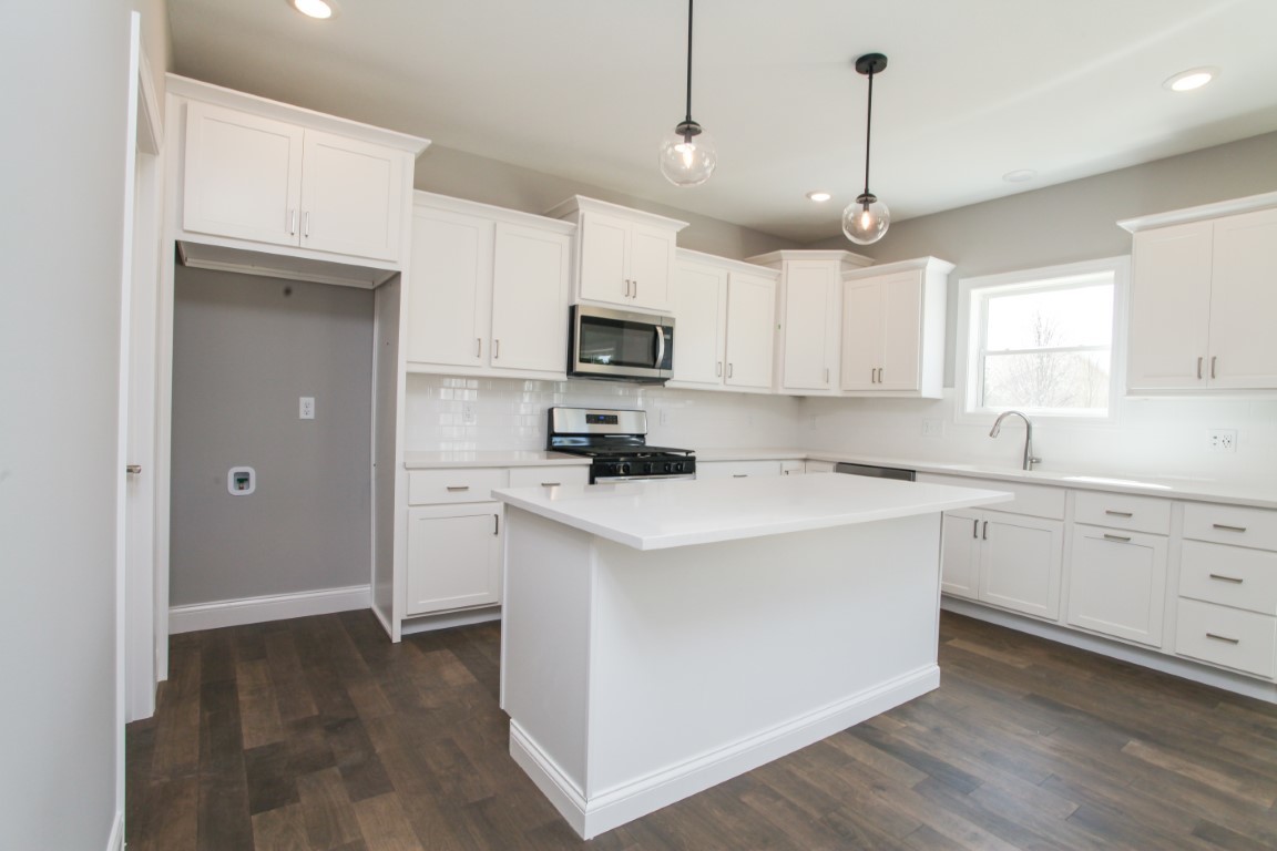 9 Brookstone Circle Bloomington, IL 61704 - Photo 8 of 40 a kitchen with granite countertop a refrigerator a sink and white cabinets