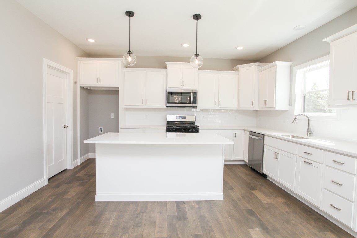 9 Brookstone Circle Bloomington, IL 61704 - Photo 9 of 40 a kitchen with kitchen island a sink a stove a refrigerator and white cabinets
