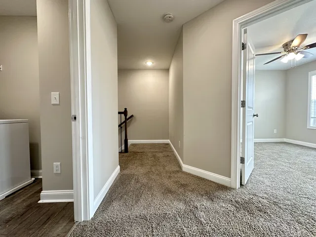 a view of a hallway with closet and wooden floor