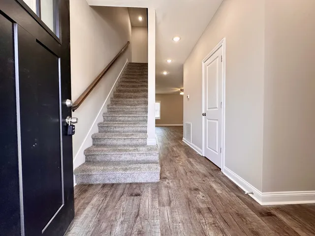 a view of entryway and hall with wooden floor