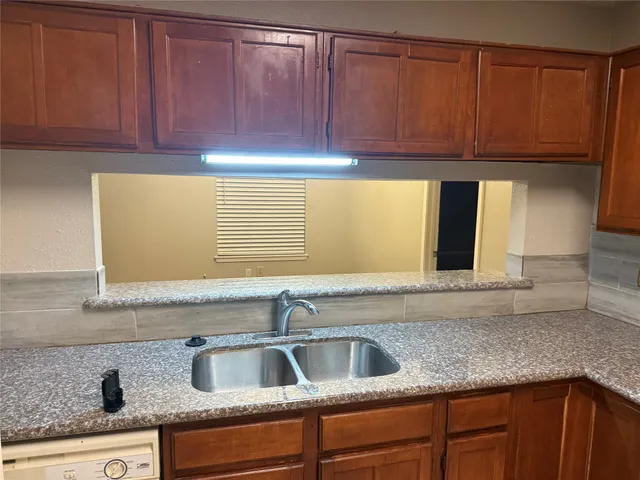 a kitchen with granite countertop a sink and cabinets
