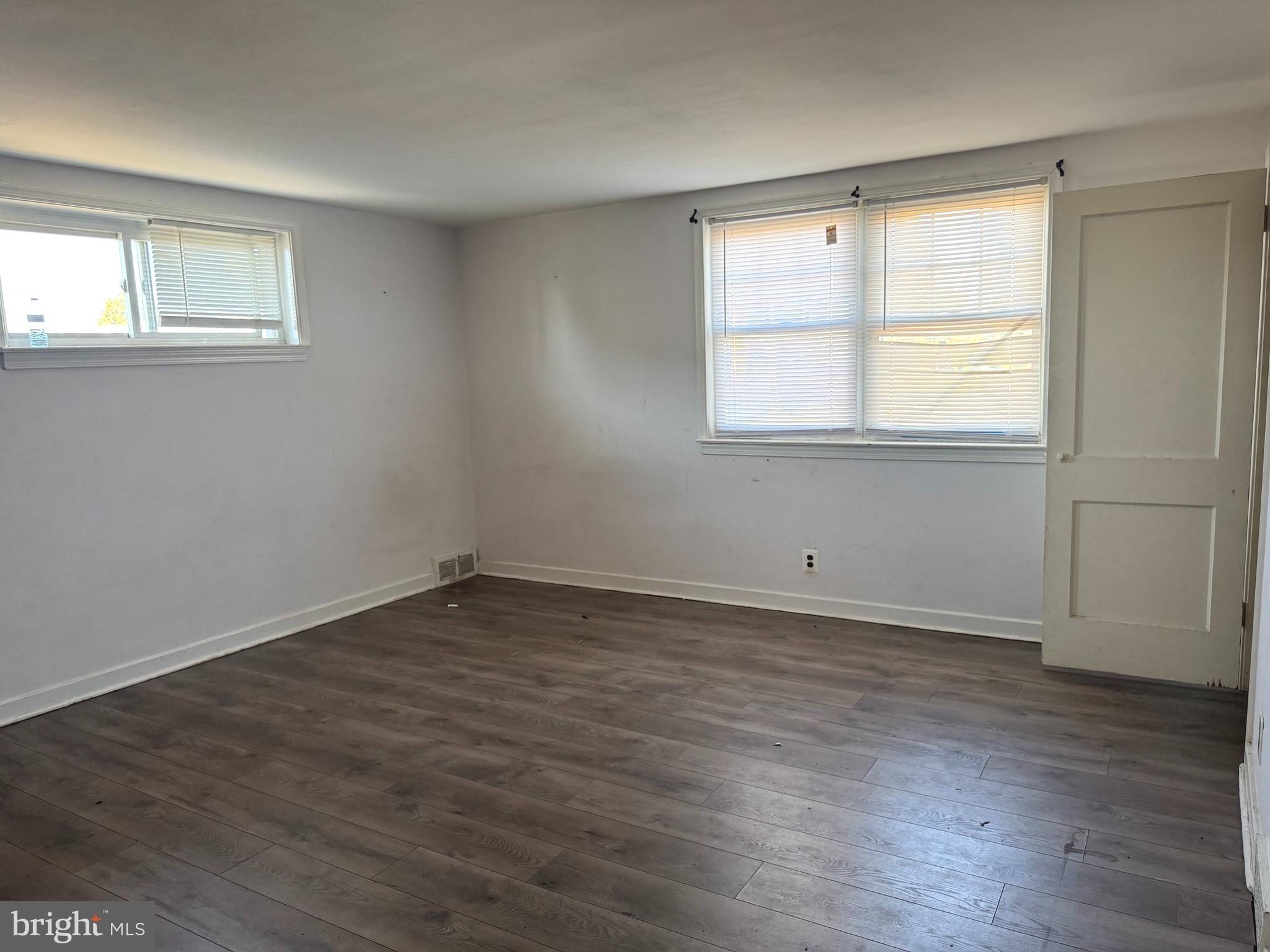 7736 Gilbert Street Philadelphia, PA 19150 - Photo 7 of 13 an empty room with wooden floor and windows