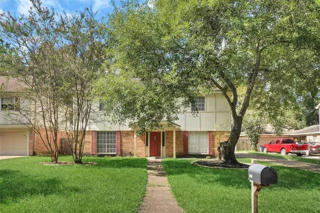 a front view of a house with a yard and trees