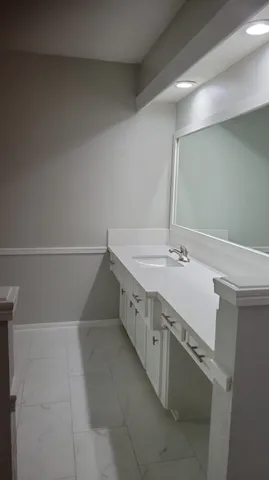 a bathroom with a granite countertop sink and a mirror