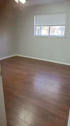 a view of a room with wooden floor and windows