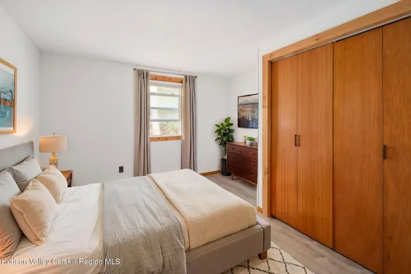a view of an empty room with wooden floor and closet