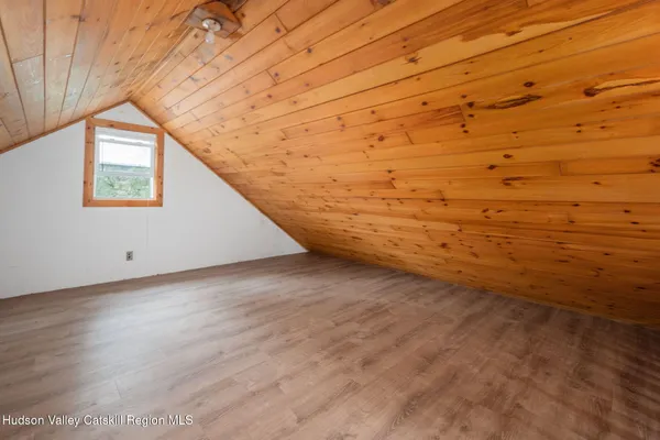 a spacious bedroom with a bed and wooden floor
