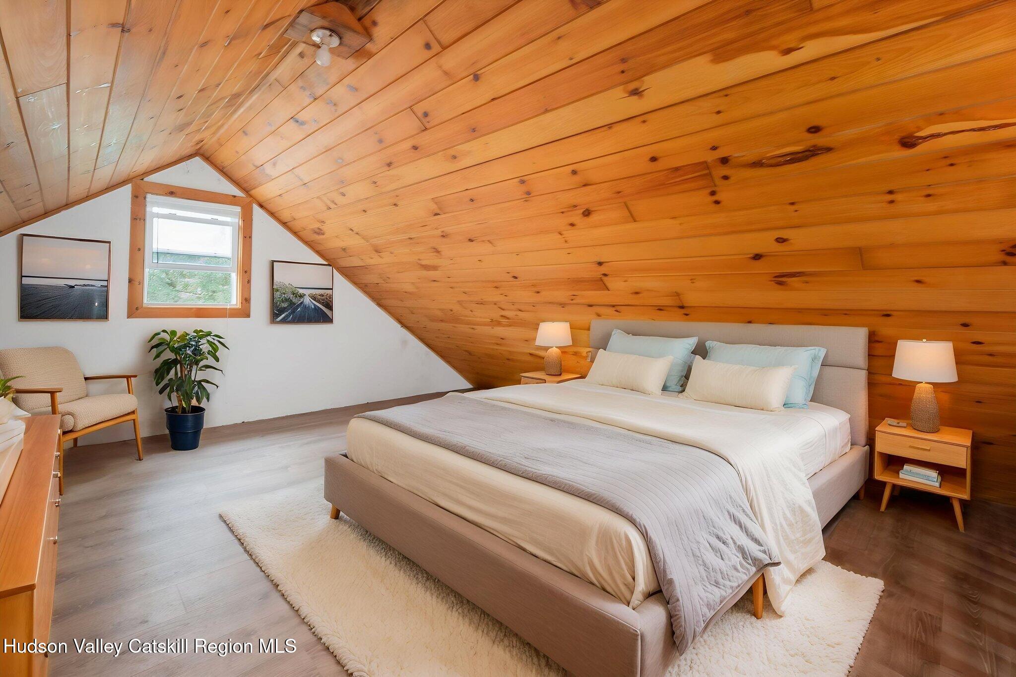 202 Blakesley Road, Unit PRIVATE Gilboa, NY 12076 - Photo 24 of 39 a spacious bedroom with a bed and wooden floor