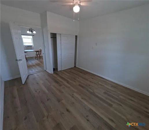 a view of a livingroom with wooden floor and a ceiling fan
