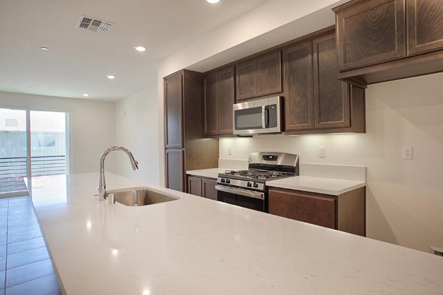 1672 17th Street Oakland, CA 94607 - Photo 10 of 24 a kitchen with stainless steel appliances a stove a sink a microwave and cabinets