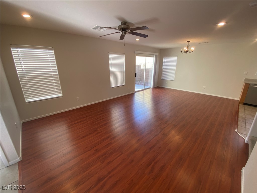 Unfurnished living room featuring light wood finished floors, ceiling fan, recessed lighting, and a chandelier