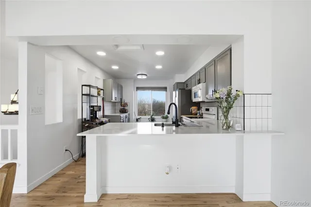 a room with stainless steel appliances a sink dishwasher a refrigerator and cabinets