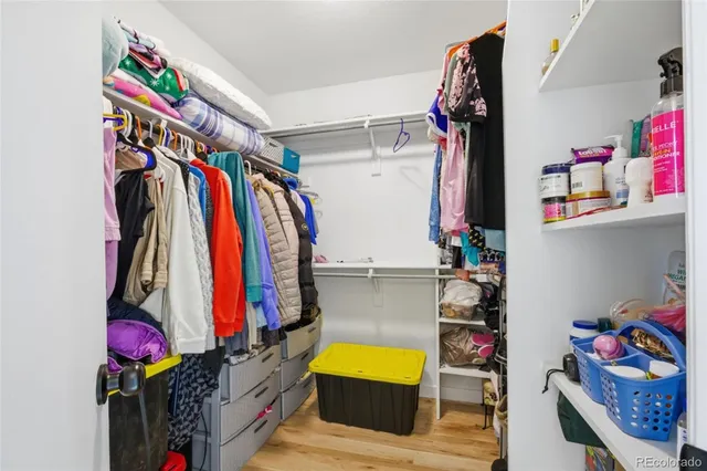 a view of walk in closet with clothes and shoes