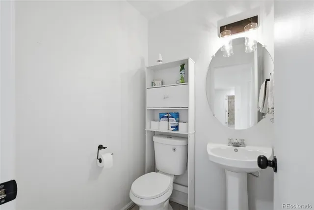 a bathroom with a toilet a sink and mirror