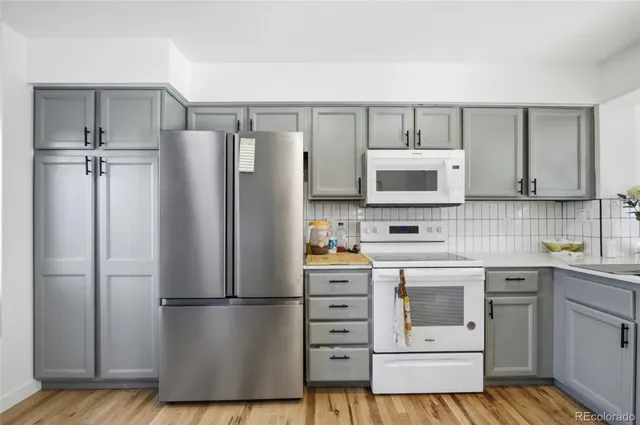 a kitchen with a refrigerator sink and cabinets