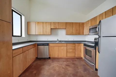 a kitchen with granite countertop a sink stove and refrigerator