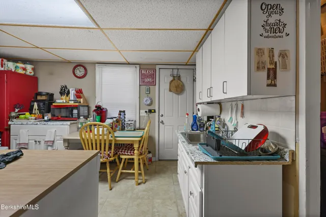 a view of a dining room with furniture and a kitchen