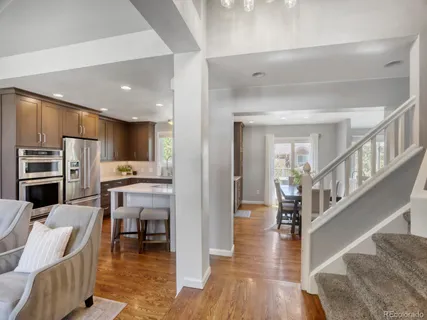 a dining hall with stainless steel appliances kitchen island granite countertop a couch and a view of living room