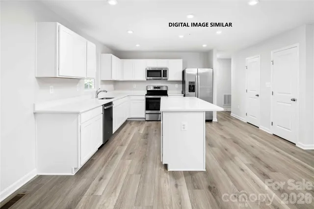 a large kitchen with a large counter top appliances and cabinets