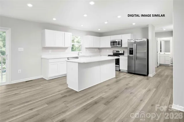 a kitchen with stainless steel appliances a refrigerator and a stove top oven