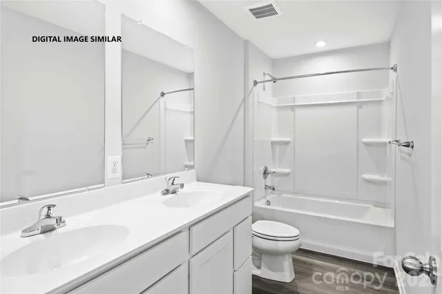 a bathroom with a granite countertop sink a toilet and shower