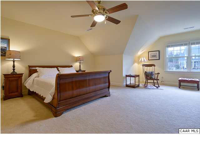 3333 Darby Road, Unit T271 Keswick, VA 22947 - Photo 20 of 32 a en suite bedroom with a bed and a lamp with window
