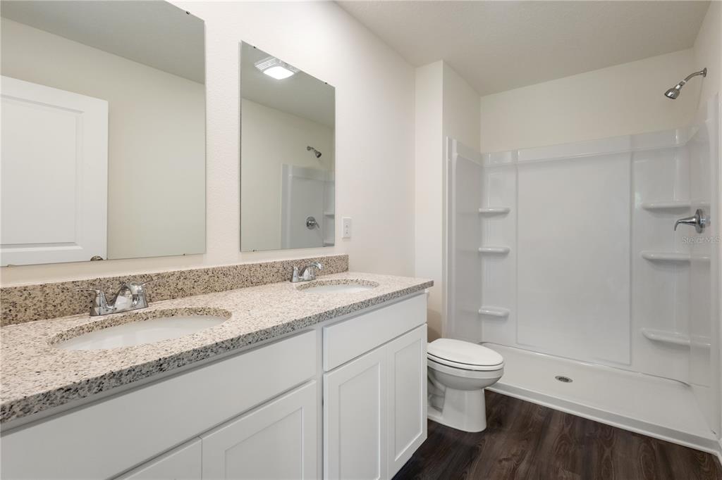 5540 Chestnut Avenue Bunnell, FL 32110 - Photo 13 of 13 a bathroom with a granite countertop sink a toilet and shower