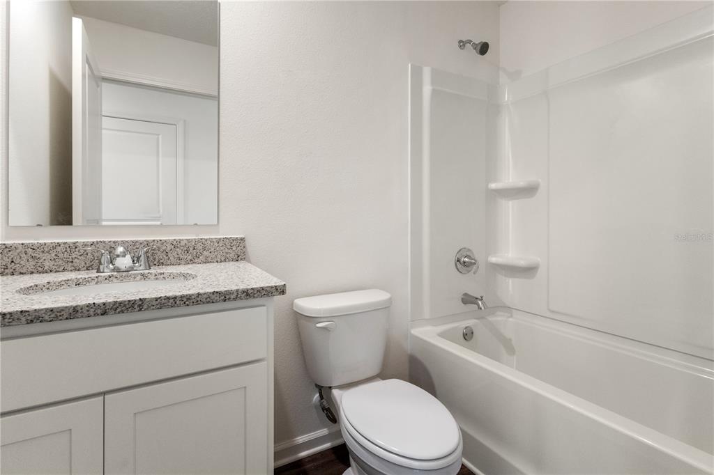 5540 Chestnut Avenue Bunnell, FL 32110 - Photo 9 of 13 a bathroom with a granite countertop toilet a sink and a bathtub