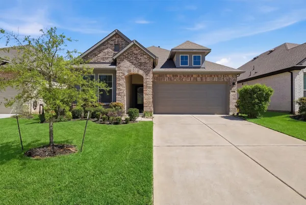 a front view of a house with a yard and trees