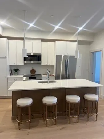 a kitchen with stainless steel appliances a dining table and chairs