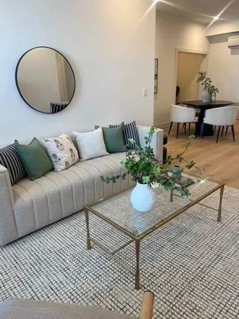 a living room with furniture a dining table and a potted plant
