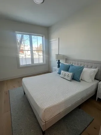 a bedroom with a bed and a lamp on desk