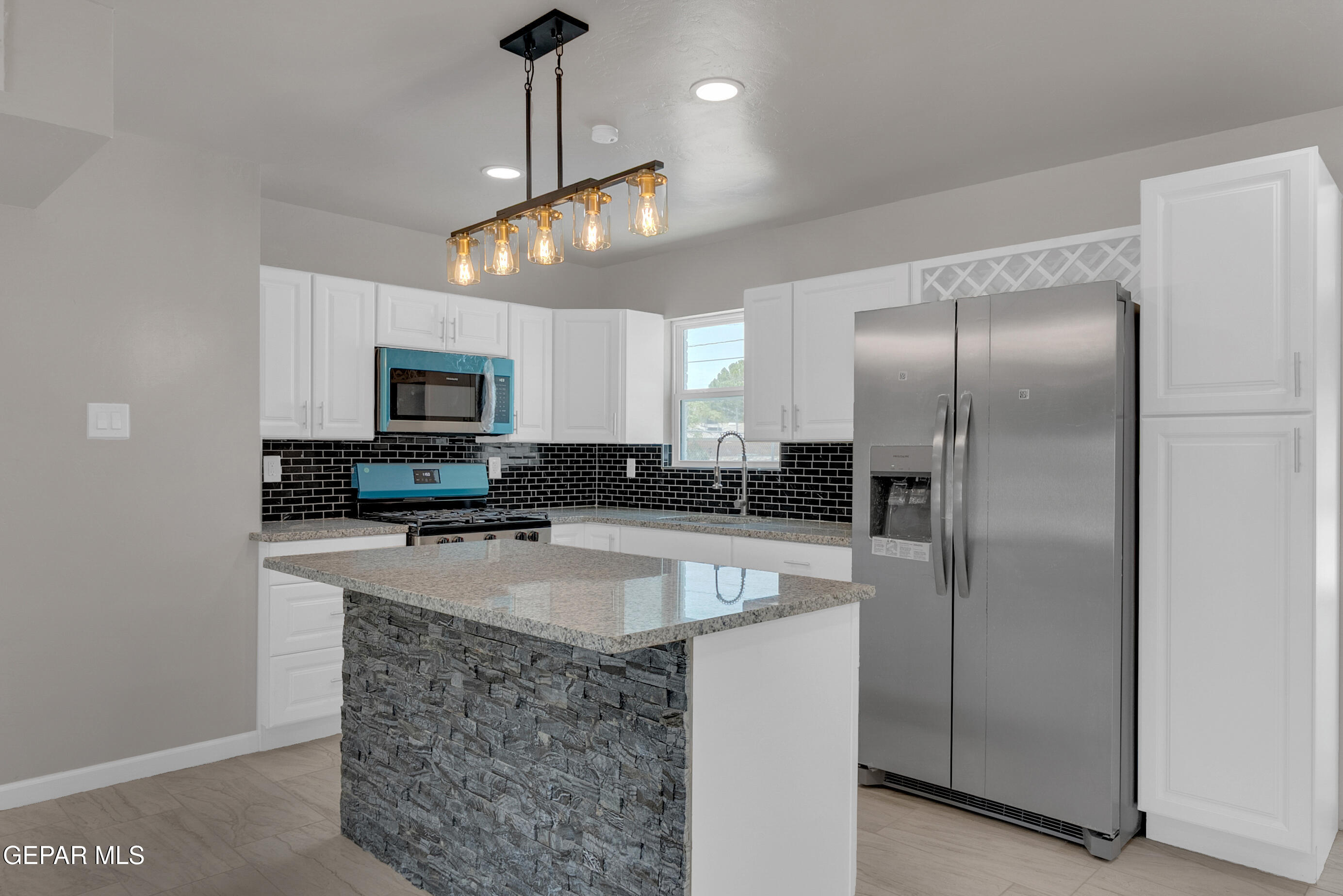 10141 Alcan Street El Paso, TX 79924 - Photo 12 of 49 a kitchen with stainless steel appliances granite countertop a sink a refrigerator and microwave