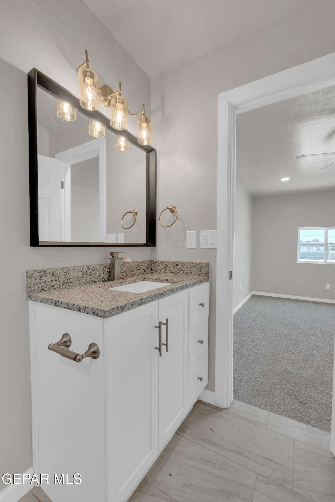 10141 Alcan Street El Paso, TX 79924 - Photo 31 of 49 a bathroom with a granite countertop sink and a mirror