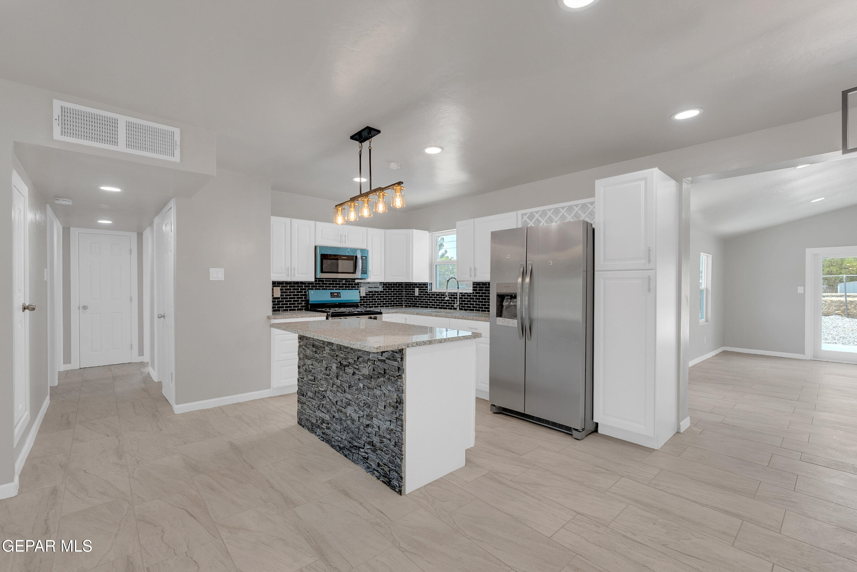 10141 Alcan Street El Paso, TX 79924 - Photo 9 of 49 a kitchen with granite countertop a refrigerator and a stove top oven