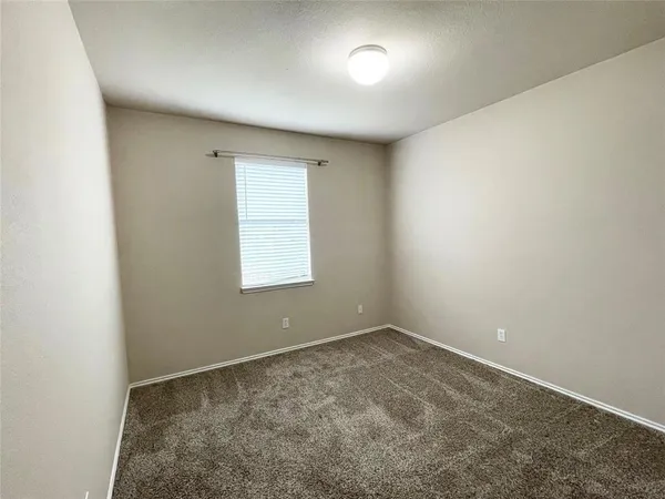 an empty room with a ceiling fan and windows