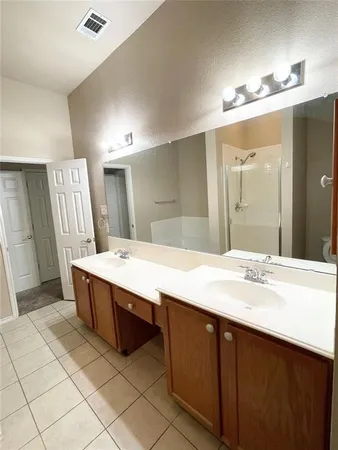 a bathroom with a double vanity sink toilet mirror and shower
