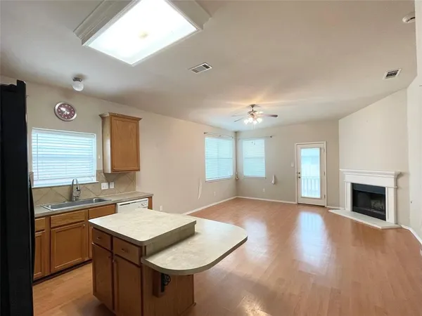 a kitchen with a sink cabinets and wooden floor