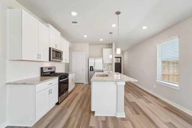 a kitchen with a stove a sink and a microwave