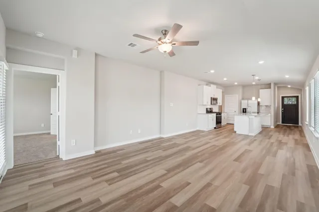 a view of a livingroom with a furniture wooden floor and a ceiling fan