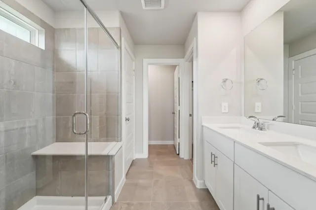 a spacious bathroom with a granite countertop sink a mirror and shower